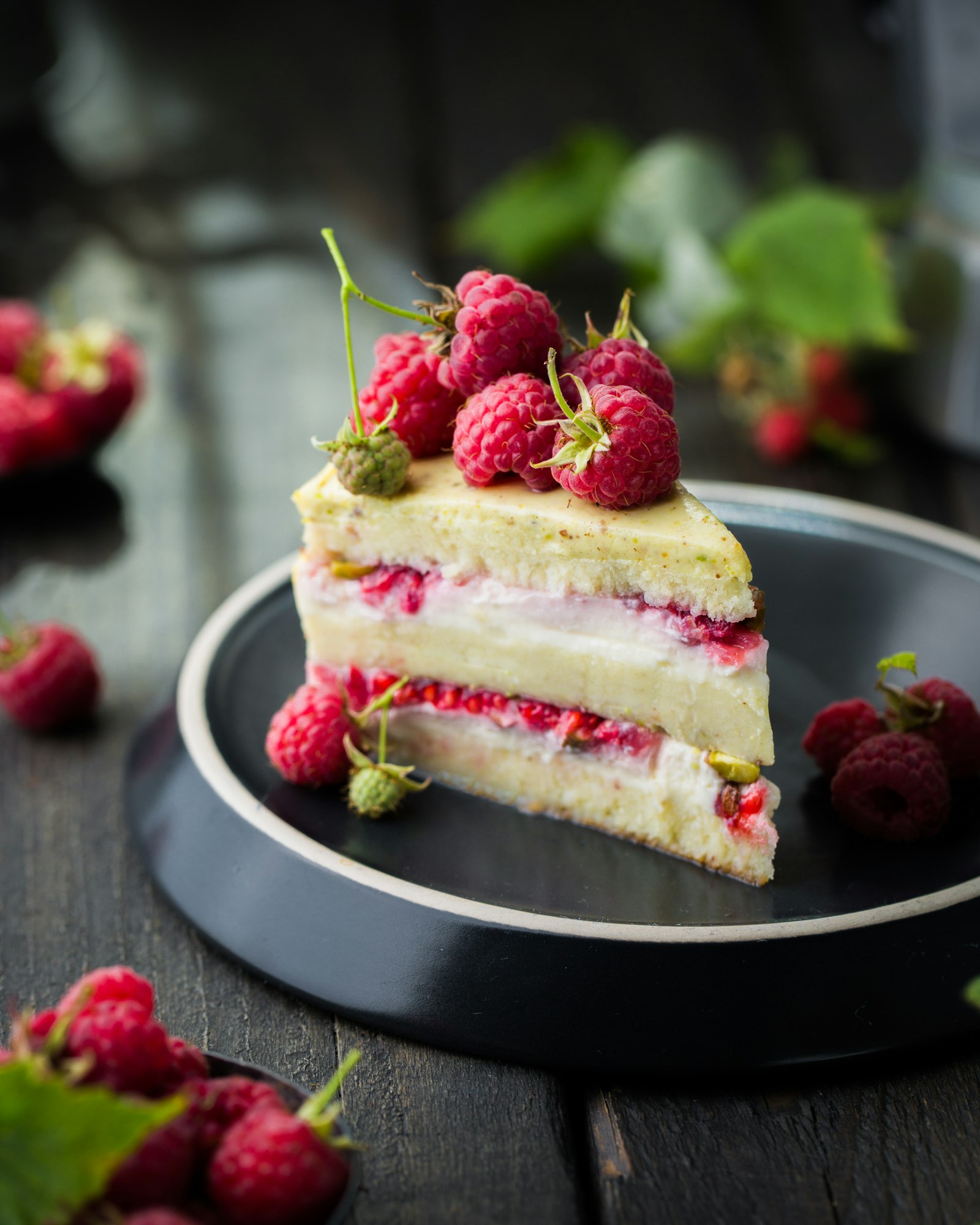 Slice of raspberry layer cake on a black plate