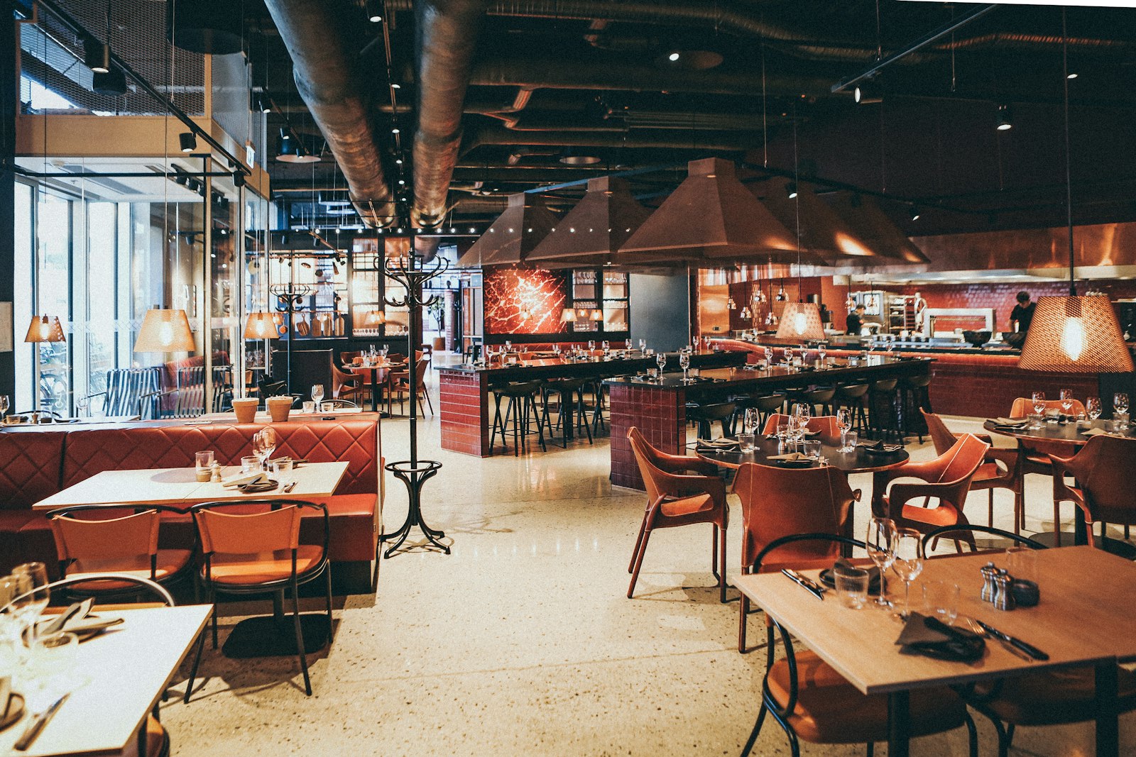 Moody dining room with copper range hoods and leather booths
