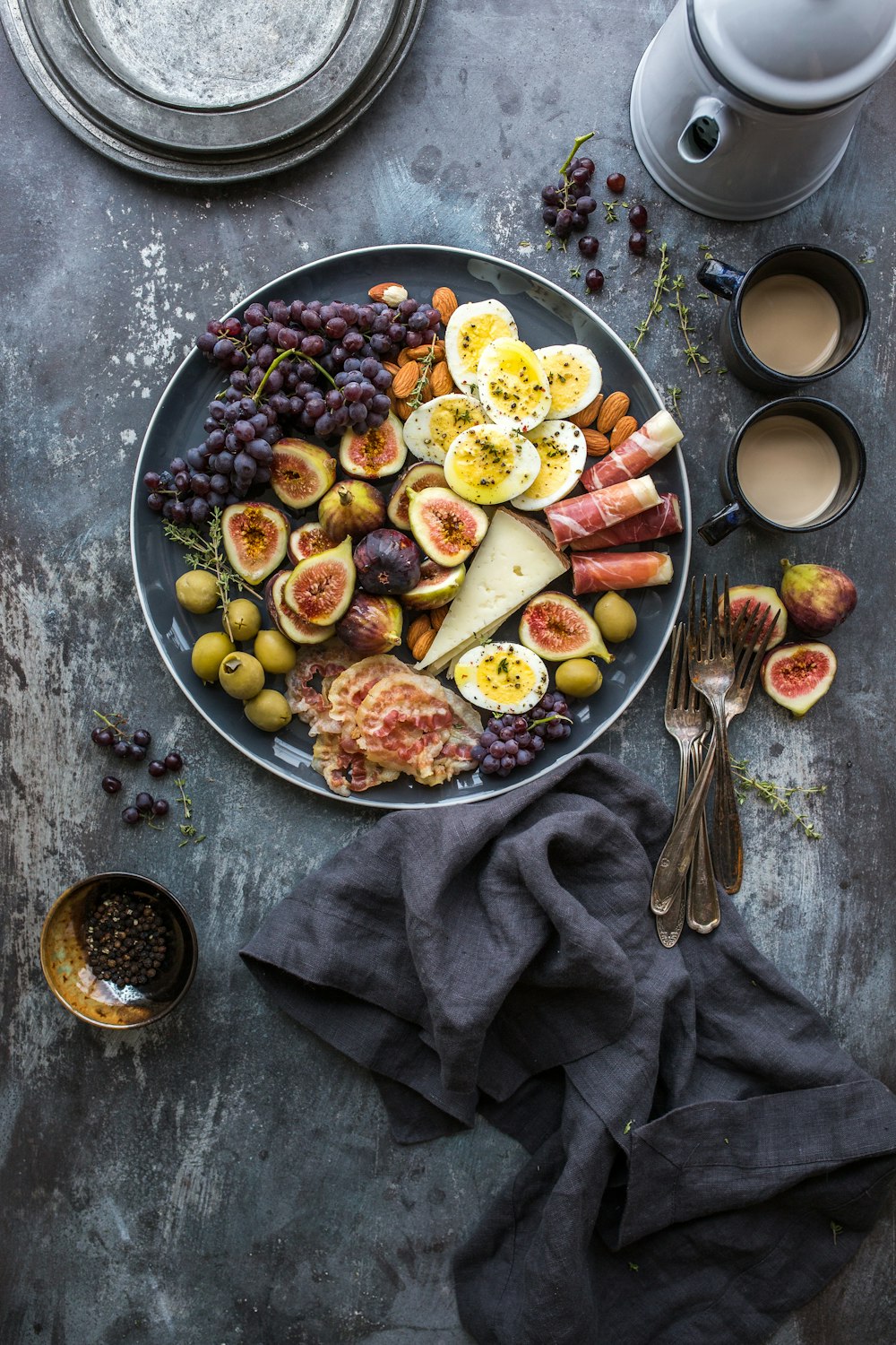 Dark moody grazing board with cheeses, fruit and charcuterie