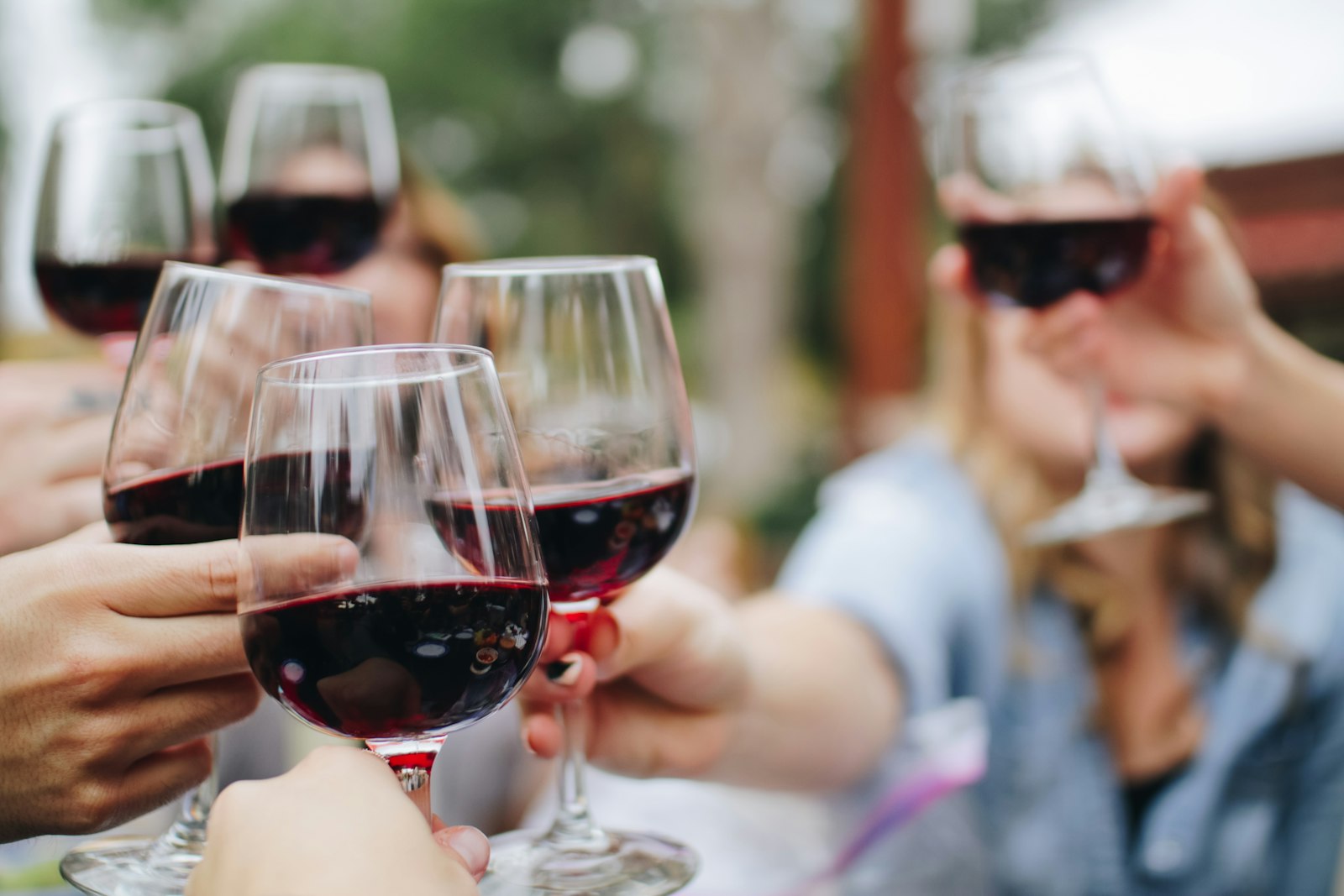 Red wine glasses raised in a cheers toast