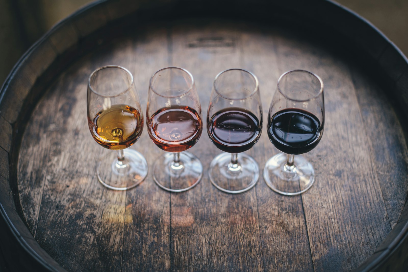 Dark moody wine-tasting flight on an oak barrel